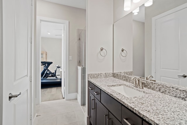 bathroom with tile patterned flooring, a shower stall, vanity, and baseboards