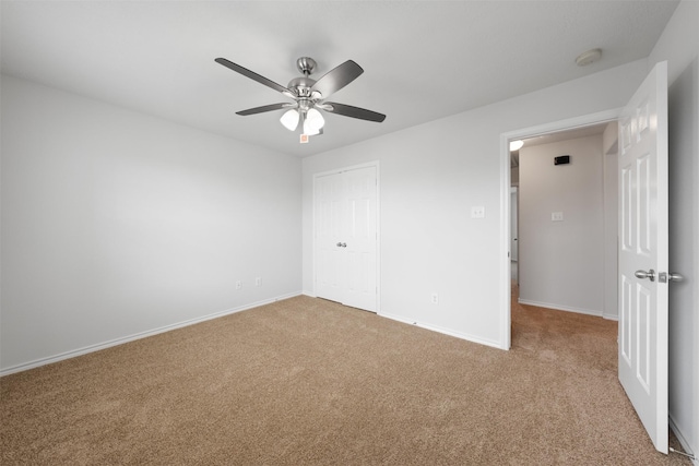 unfurnished bedroom featuring a ceiling fan, carpet, baseboards, and a closet