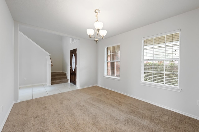 empty room with a notable chandelier, light tile patterned floors, stairway, light carpet, and baseboards