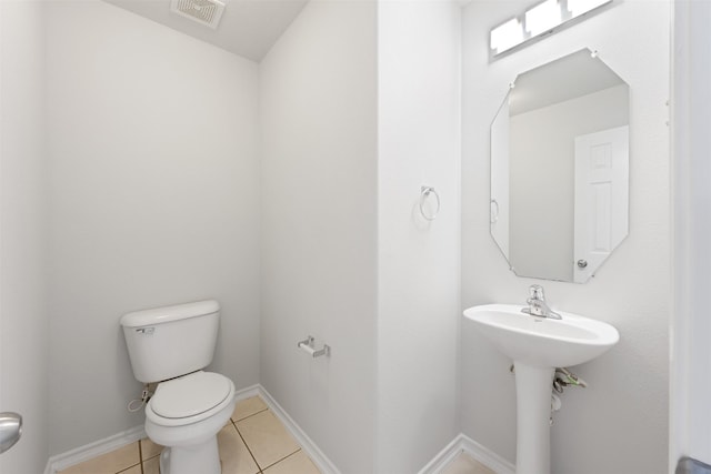 bathroom with tile patterned flooring, baseboards, visible vents, and toilet