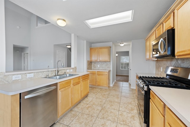 kitchen featuring light tile patterned floors, appliances with stainless steel finishes, light countertops, light brown cabinets, and a sink