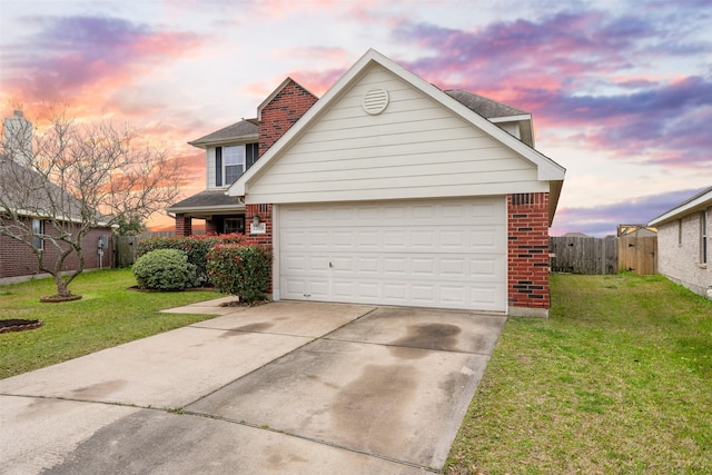 traditional-style house with driveway, fence, a front lawn, and brick siding