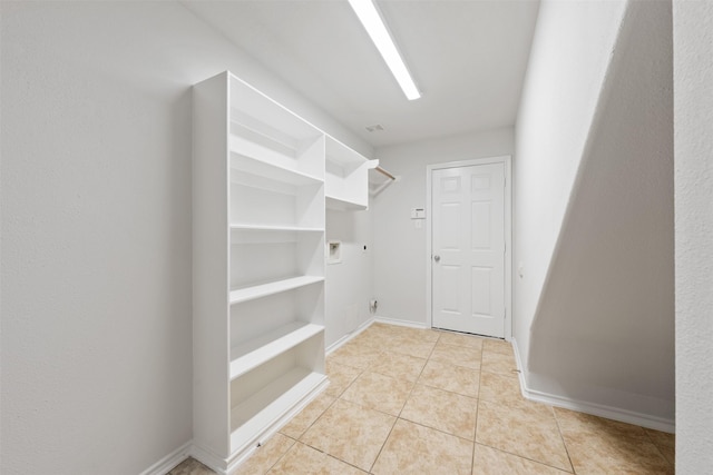 walk in closet with light tile patterned floors