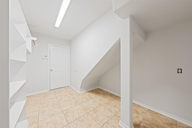 interior space featuring tile patterned flooring, visible vents, and baseboards