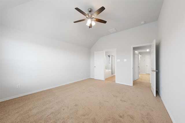 unfurnished bedroom with ceiling fan, light colored carpet, baseboards, vaulted ceiling, and ensuite bath