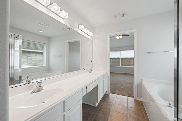 full bath featuring tile patterned flooring, a garden tub, and a sink