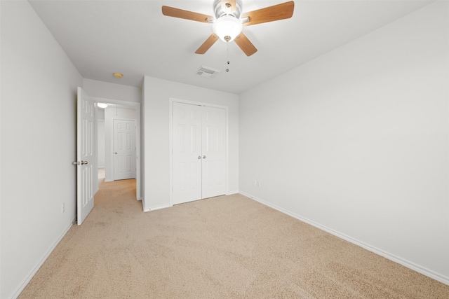 unfurnished bedroom with light carpet, a closet, visible vents, and baseboards