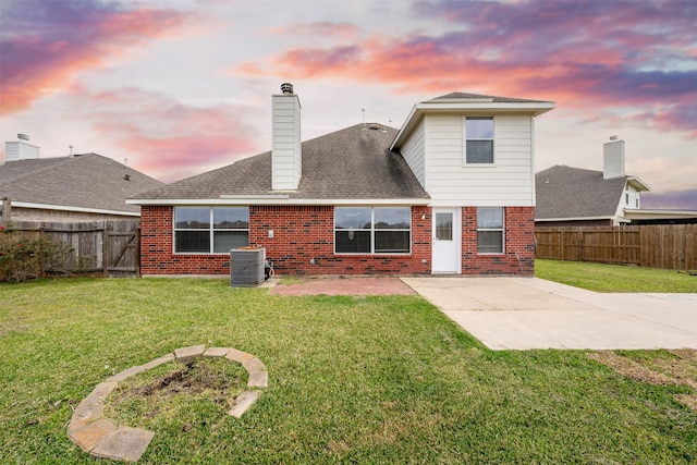 back of house with a patio, brick siding, a chimney, and central AC unit