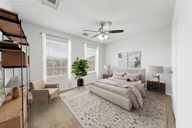 carpeted bedroom with a ceiling fan, visible vents, and baseboards