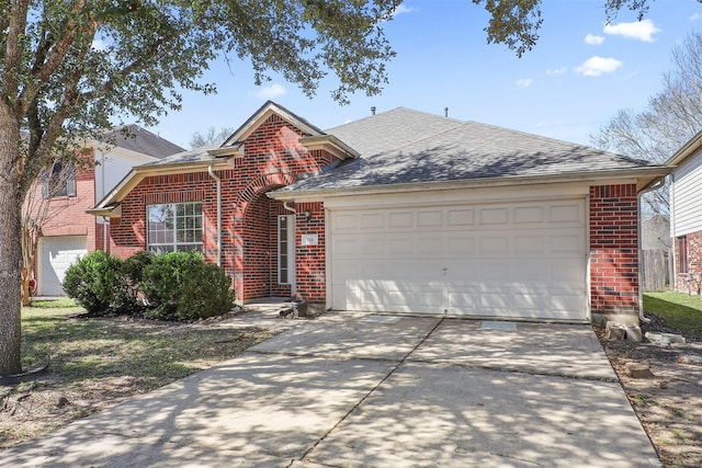 traditional-style house with a garage, brick siding, a shingled roof, and driveway