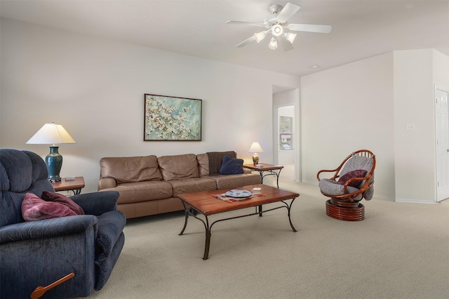 living area featuring ceiling fan, baseboards, and light colored carpet