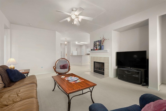 living area featuring ceiling fan, a fireplace, carpet flooring, and baseboards