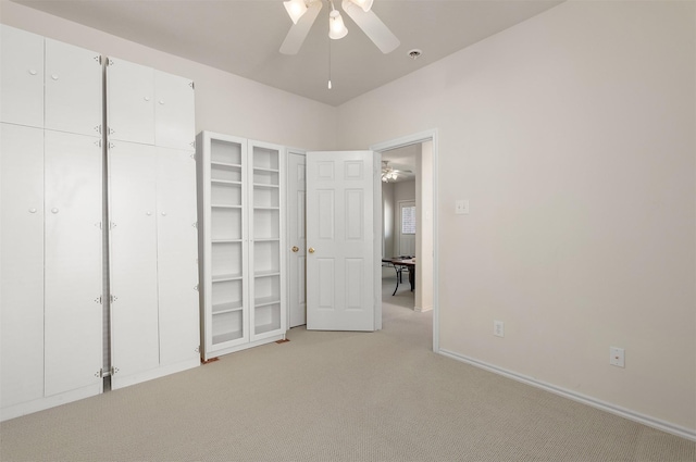 unfurnished bedroom with light colored carpet, ceiling fan, and baseboards