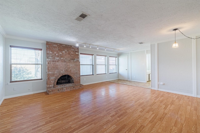 unfurnished living room with visible vents, a fireplace, a textured ceiling, and light wood-style floors