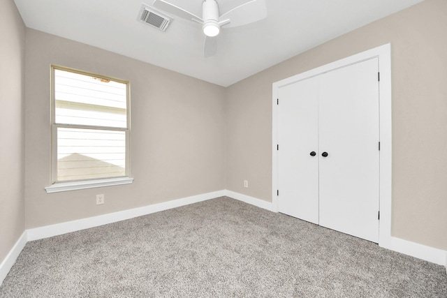 unfurnished bedroom with a closet, visible vents, a ceiling fan, carpet flooring, and baseboards