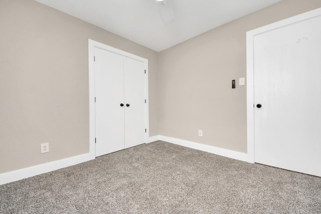 unfurnished bedroom with carpet floors, baseboards, and a closet