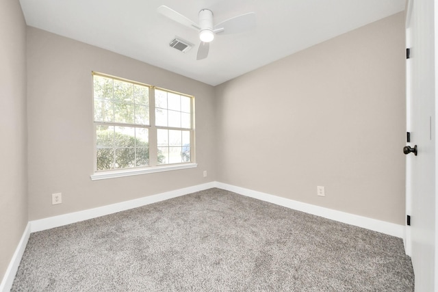 spare room with carpet floors, baseboards, visible vents, and a ceiling fan