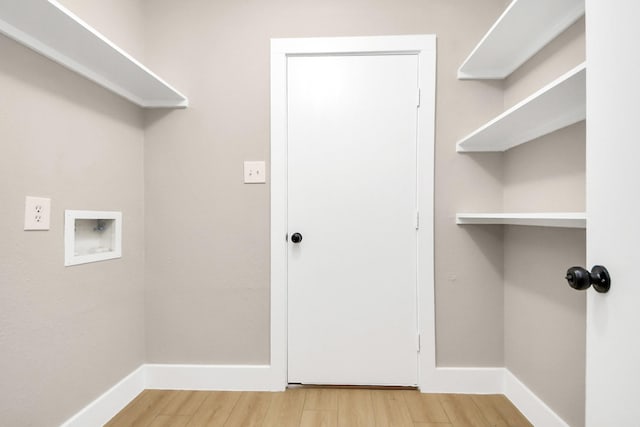 laundry area featuring hookup for a washing machine, laundry area, baseboards, and light wood finished floors