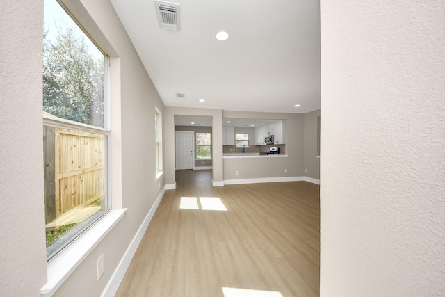 unfurnished living room featuring recessed lighting, visible vents, baseboards, and wood finished floors