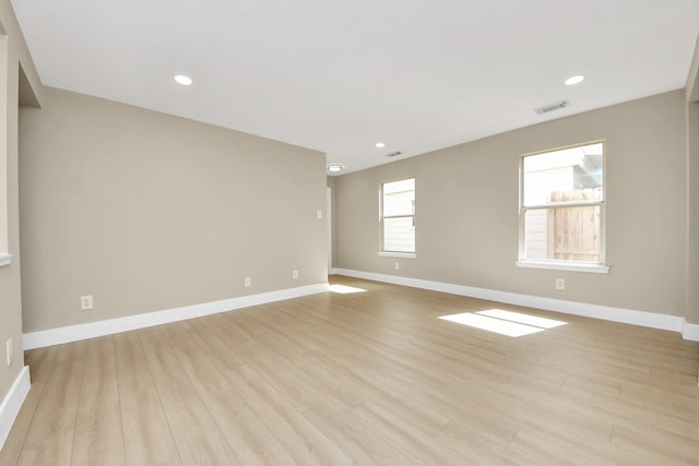 unfurnished room featuring light wood-style floors, visible vents, baseboards, and recessed lighting