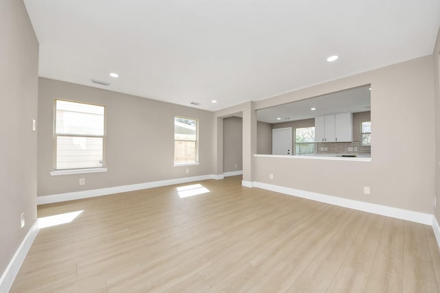 unfurnished living room with recessed lighting, light wood-type flooring, visible vents, and baseboards