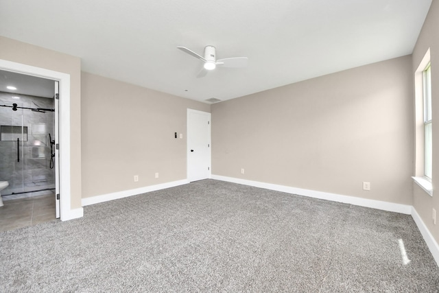 unfurnished bedroom with carpet flooring, ensuite bath, baseboards, and multiple windows