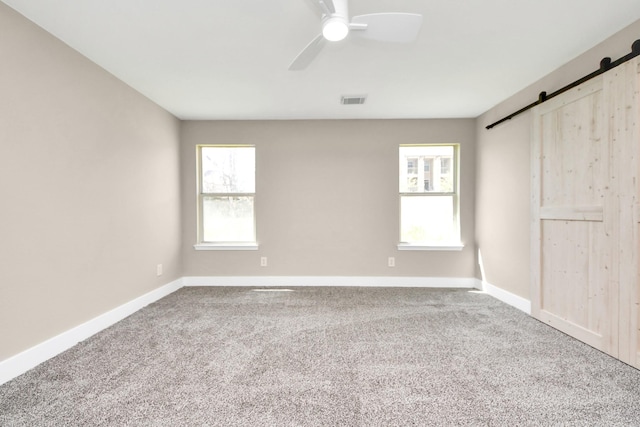 interior space with a healthy amount of sunlight, carpet, and a barn door