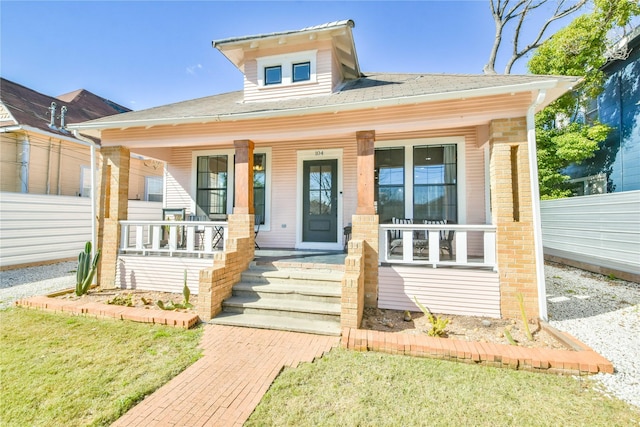 bungalow-style home featuring a porch and fence