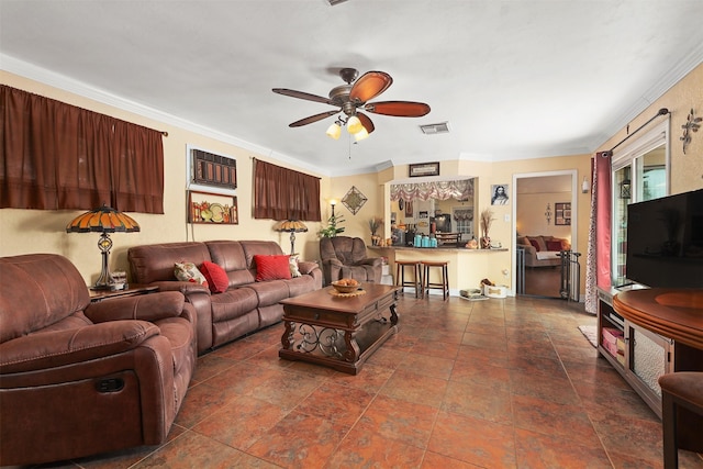 living room featuring a ceiling fan, visible vents, and crown molding