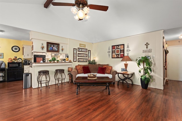 living area with vaulted ceiling with beams, ceiling fan, and wood finished floors