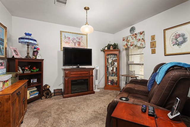 living area with carpet, visible vents, and a glass covered fireplace