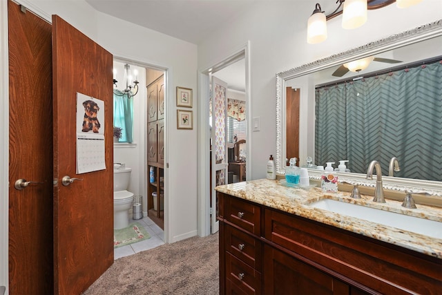 full bathroom with toilet, an inviting chandelier, tile patterned flooring, and vanity