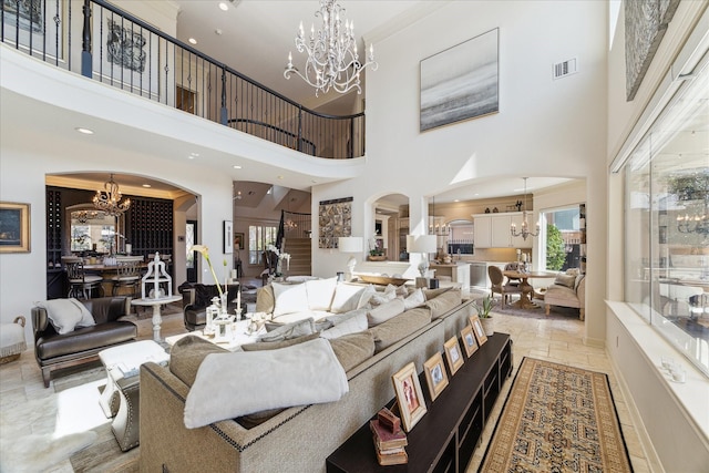 living room with visible vents, baseboards, a notable chandelier, and stone tile flooring