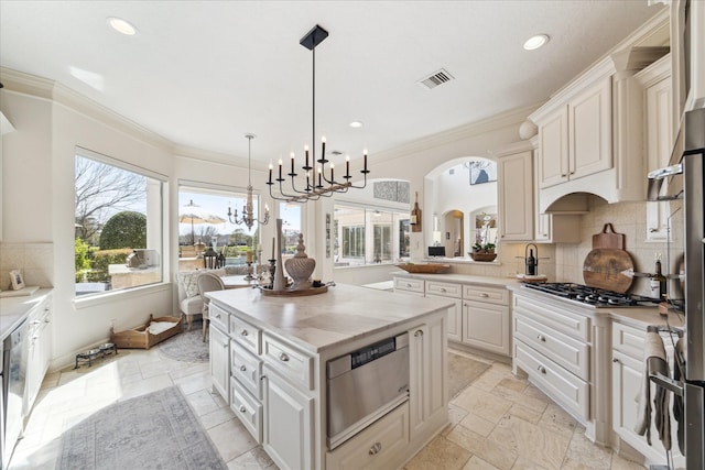 kitchen with a warming drawer, visible vents, tasteful backsplash, and stone tile flooring