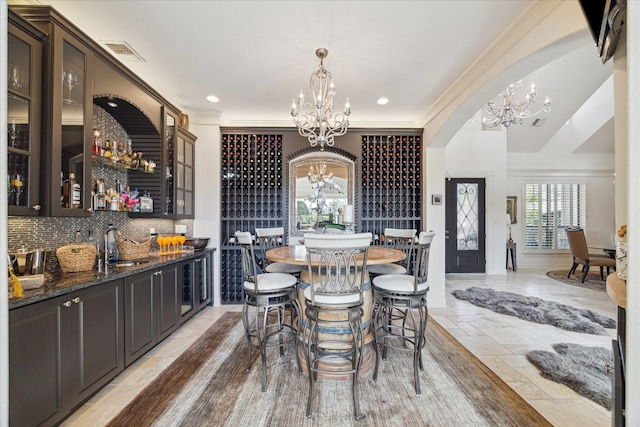 dining space with visible vents, crown molding, recessed lighting, stone tile flooring, and a notable chandelier