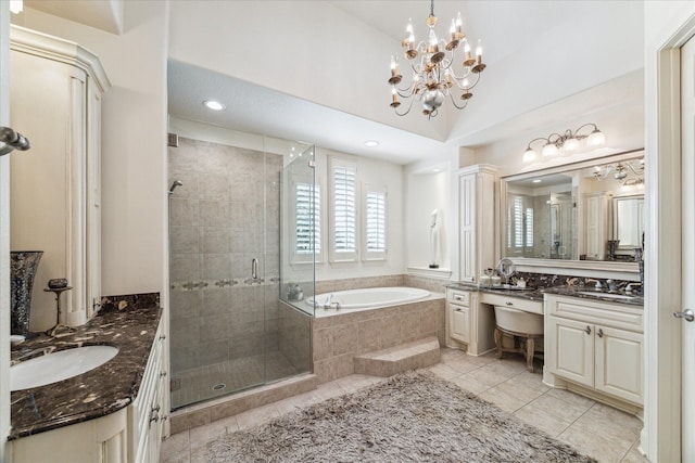 bathroom with two vanities, a stall shower, a sink, tile patterned flooring, and a garden tub