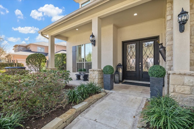 doorway to property with french doors, covered porch, and stucco siding