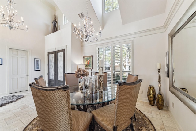 dining space with visible vents, stone tile flooring, french doors, an inviting chandelier, and a towering ceiling