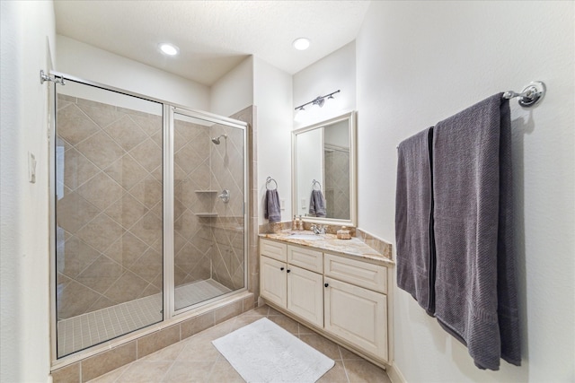 bathroom with tile patterned flooring, vanity, and a stall shower