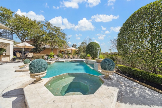 pool with an in ground hot tub and a patio area