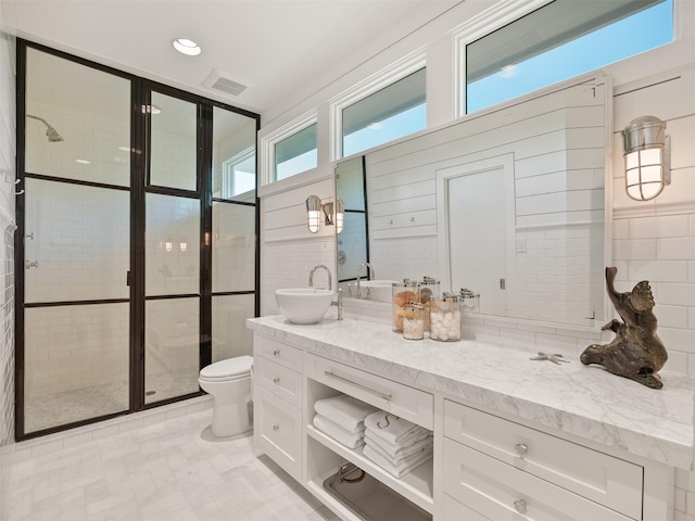 bathroom featuring visible vents, decorative backsplash, tiled shower, toilet, and vanity