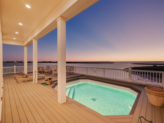 pool at dusk with a deck with water view