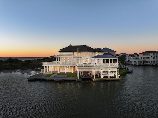 back of house at dusk with a water view