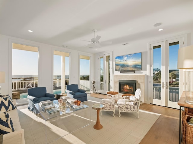 living room featuring recessed lighting, visible vents, a lit fireplace, and wood finished floors