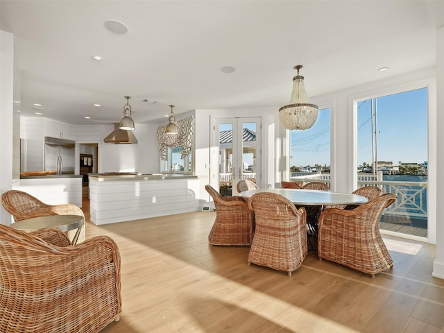 dining room with light wood finished floors, a chandelier, french doors, and recessed lighting