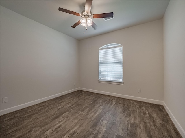 spare room featuring dark wood finished floors, ceiling fan, and baseboards