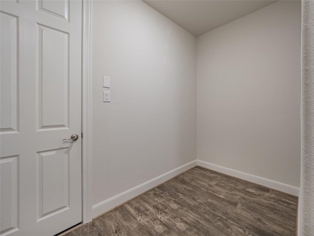 spare room with baseboards and wood finished floors