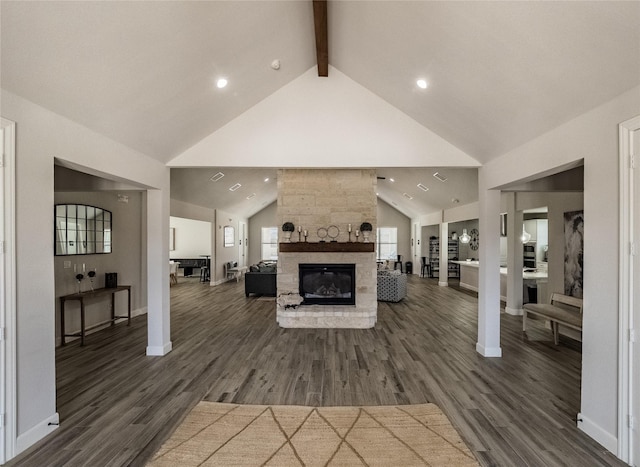 living area with dark wood-type flooring, high vaulted ceiling, a fireplace, and beam ceiling