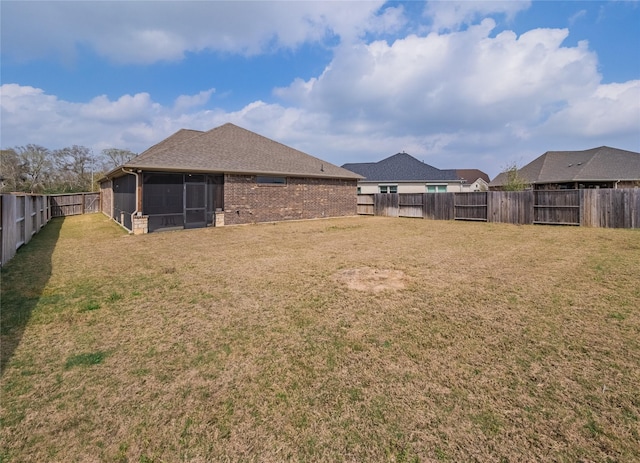 view of yard with a fenced backyard and a sunroom