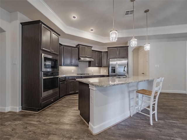 kitchen with visible vents, a sink, stainless steel appliances, a raised ceiling, and dark brown cabinets